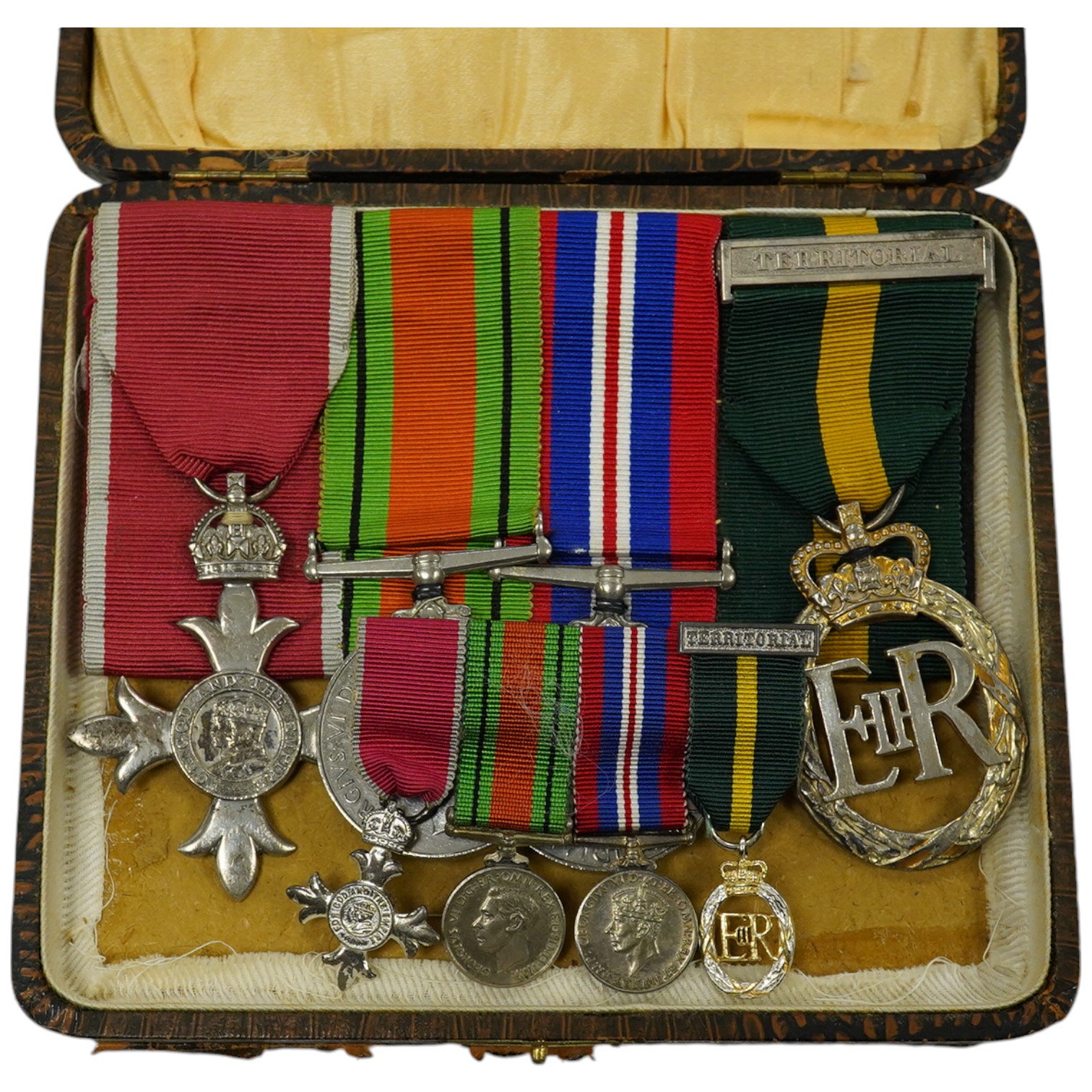 A group of 4 medals including MBE in display case